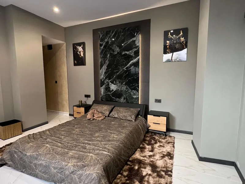 Dormitorio terminado con cabecero de mármol y suelo porcelánico