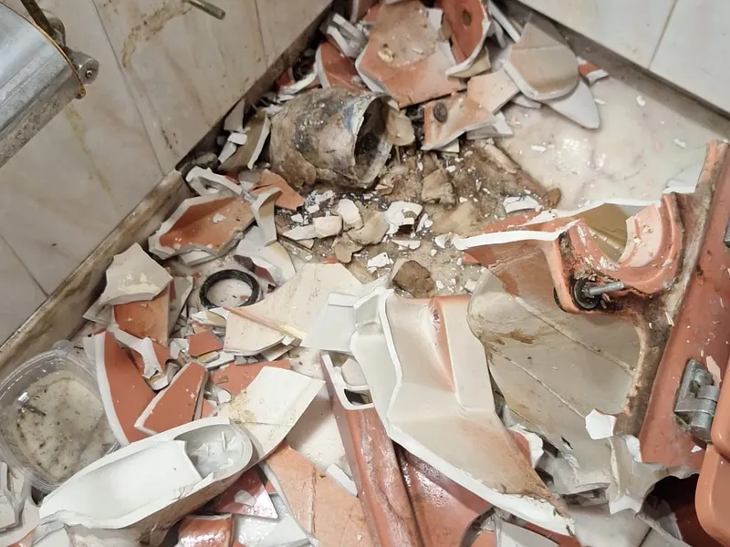 Baño en demolición: los sanitarios de gres retirados y partidos sobre el suelo